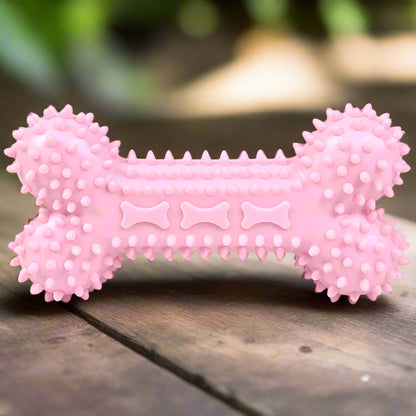 Pink bone-shaped dog toy with textured surface on a white background