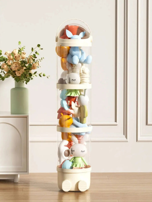 Stack of colorful animal figurines in a transparent tube on a wooden floor with a white cabinet and decorative plant in the background.